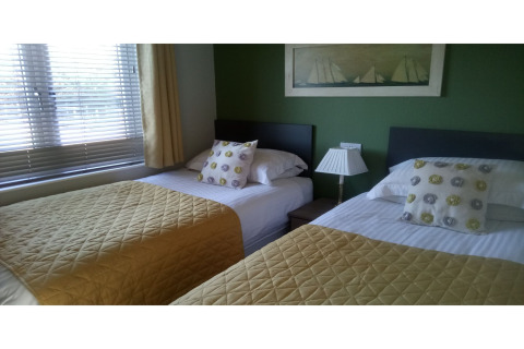 Et lyst værelse i New Puddledock Lodge, Storbritannien, med to enkeltsenge og moderne indretning.
