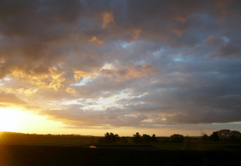 Coucher de soleil sur les champs à New Puddledock Lodge au Royaume-Uni, avec des nuages dramatiques.