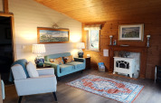 Cozy living room in a wooden cabin with fireplace, art, and colorful furniture at Tore Petty, UK.