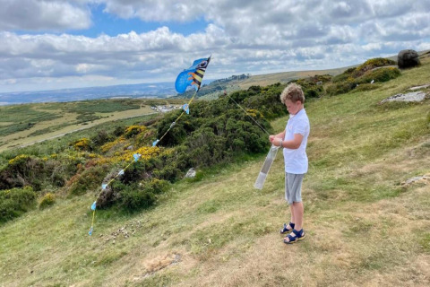 Dreng flyver en farverig drage på en bakke med grøn natur ved Little Dunley - Apple Lodge, UK