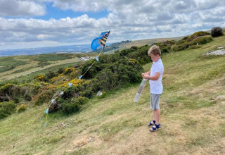Dreng flyver en farverig drage på en bakke med grøn natur ved Little Dunley - Apple Lodge, UK