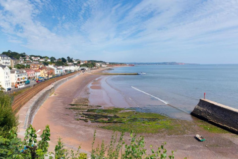 Kystudsigt fra Little Dunley - Apple Lodge i Storbritannien med strand, hav og farverige bygninger.