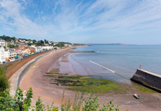 Kystudsigt fra Little Dunley - Apple Lodge i Storbritannien med strand, hav og farverige bygninger.