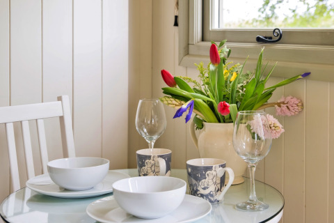 Tavola della colazione con fiori presso Hay and Hedgerow Glamping nel Regno Unito.