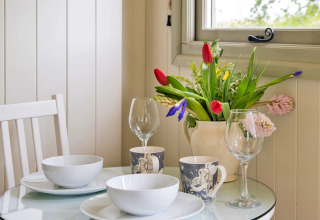 Tavola della colazione con fiori presso Hay and Hedgerow Glamping nel Regno Unito.