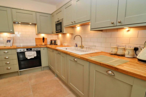 Moderne keuken in Little Rissington - Barn Four, Verenigd Koninkrijk, met houten werkblad en lichte kasten.
