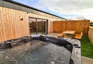Buitenzone bij Little Rissington - Barn Four met jacuzzi, terras en houten banken in het Verenigd Koninkrijk.