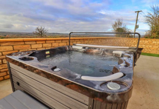 Bubbelbad buiten op het terras bij Little Rissington - Barn Four, met zicht op het Engels landschap.