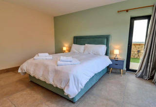 Moderne slaapkamer in Little Rissington - Barn Four met dubbel bed, nachtkastjes en een raam in het Verenigd Koninkrijk.