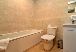 Moderne badkamer met bad, toilet, wastafel en spiegel in Little Rissington - Barn Four, Verenigd Koninkrijk.