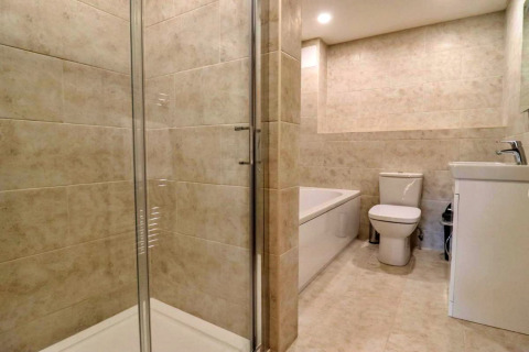 Moderne badkamer met douche, bad, toilet en wastafel bij Little Rissington - Barn Four in het Verenigd Koninkrijk.