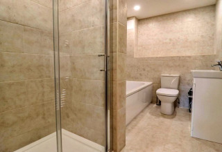 Moderne badkamer met douche, bad, toilet en wastafel bij Little Rissington - Barn Four in het Verenigd Koninkrijk.