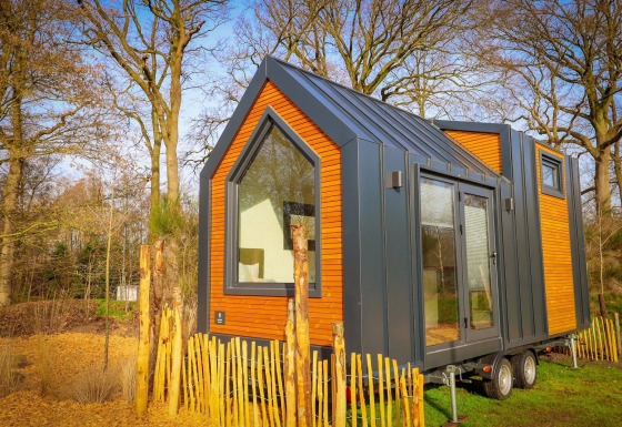 Casa diminuta y moderna con revestimiento de madera y metal, ubicada en el bosque de Holiday Park Sallandshoeve.