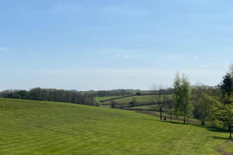 Zicht op groene velden en glooiende heuvels vanuit Little Rissington - Barn Four lodge in het Verenigd Koninkrijk.