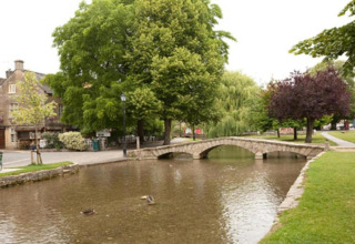 Sfeervol zicht op stenen brug, rivier en bomen bij Little Rissington - Barn Four, Verenigd Koninkrijk.