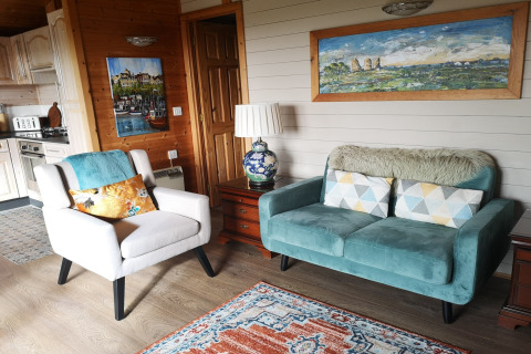 Accogliente salotto nella cabina Tore Petty con divano blu, poltrona e decorazioni nel Regno Unito.