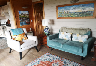 Accogliente salotto nella cabina Tore Petty con divano blu, poltrona e decorazioni nel Regno Unito.