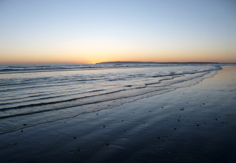 Sunset by the sea seen from the beach near the cabin Tore Petty, gentle waves and a peaceful sky.