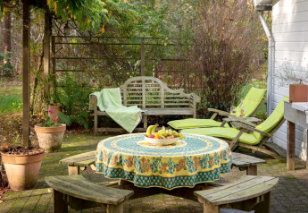 Gezellig terras bij chalet 'Het Beerenbos' in België met tafel, banken, ligzetels en een fruitschaal.