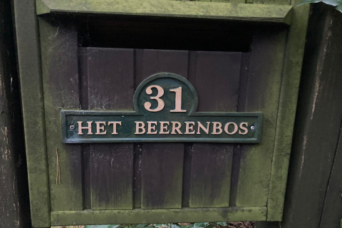 Numero civico 31 e targa 'Het Beerenbos' su un cancello muschioso di chalet in Belgio.