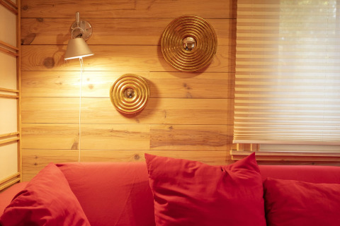 Accogliente angolo soggiorno nello chalet Het Beerenbos, Belgio, con divano rosso e parete in legno.