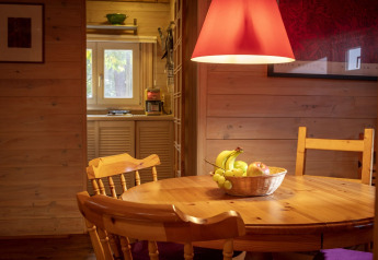 Acogedor comedor de madera en el chalet Het Beerenbos, Bélgica, con una cesta de frutas sobre la mesa.