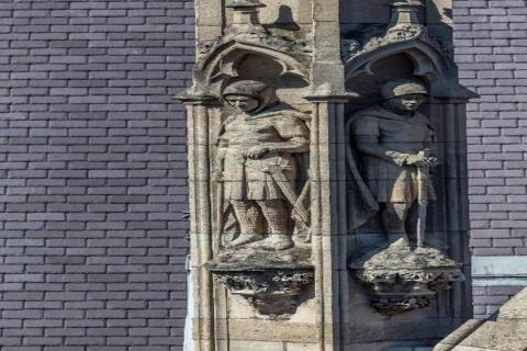 Sculture in pietra di cavalieri al chalet 'Het Beerenbos' in Belgio, con archi gotici e dettagli raffinati.