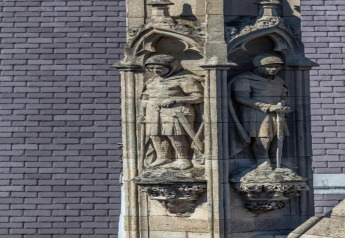 Esculturas de caballeros en piedra en el chalet 'Het Beerenbos' en Bélgica, con arcos góticos detallados.