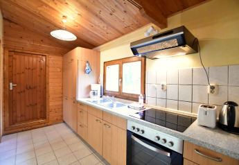 Bright wooden kitchen inside a cabin at Platz im Grünen 2, Germany, featuring modern appliances and window.