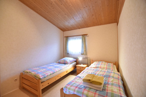 Gezellige slaapkamer met twee éénpersoonsbedden in de cabin Platz im Grünen 2 in Duitsland.