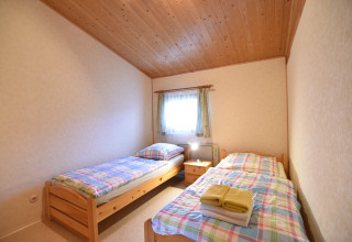 Gezellige slaapkamer met twee éénpersoonsbedden in de cabin Platz im Grünen 2 in Duitsland.