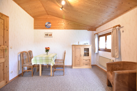 Woonkamer van ‘Platz im Grünen 2’ hut in Duitsland met houten meubels en uitnodigende uitstraling.