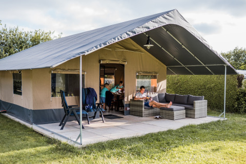 Safaritent bij Resort Nommerlayen 3 in Luxemburg, gezin ontspant buiten op terras met comfortabele zetels.
