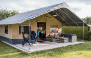 Safaritent op Resort Nommerlayen 3 in Luxemburg, familie ontspant buiten op het terras met tuinmeubilair.