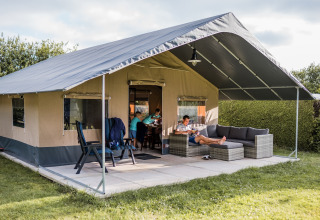Safaritent bij Resort Nommerlayen 3 in Luxemburg, gezin ontspant buiten op terras met comfortabele zetels.