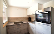 Cuisine moderne avec plaques, four et évier au complexe Bungalow «Gänseblümchen 2» en Allemagne.