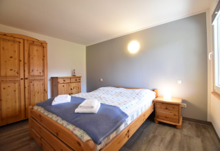 Accogliente camera da letto presso Bungalow complex «Gänseblümchen 2», Germania, con mobili in legno.