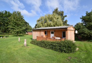 Cabaña de madera en jardín verde y soleado, complejo Bungalow Gänseblümchen 2 en Alemania.