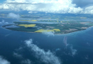 Vista aérea de la pintoresca costa alemana con campos, mar y nubes desde el complejo Bungalow Gänseblümchen 2.