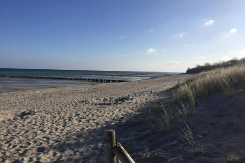 Strandudsigt fra Bungalow-komplekset «Gänseblümchen 2» i Tyskland med klitter og hav i baggrunden.