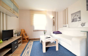 Lichte en gezellige woonkamer in Bungalowcomplex Gänseblümchen 7, Duitsland, met moderne inrichting.