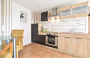 Bright modern kitchen of Bungalow complex Gänseblümchen 7 in Germany with wooden cabinets and dining area.