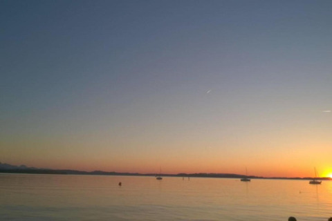 Beautiful sunset view from Bungalow complex ‘Gänseblümchen 7’ in Germany with boats on calm water.