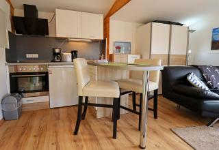 Modern cabin apartment Räuberkuhle Koserow in Germany with open kitchen, dining area and living room.
