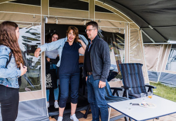 Een groep mensen geniet bij een safaritent op Resort Echternacherbrück 1 in Duitsland, lachend samen.