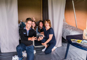 Een gezin maakt samen een selfie in een safaritent op Resort Echternacherbrück 1 in Duitsland.