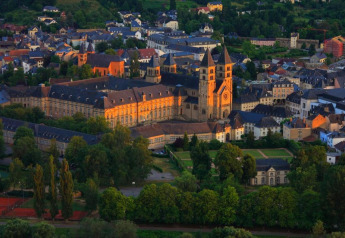 Uitzicht op Echternach in Duitsland met historische gebouwen en veel groen in avondzonlicht.
