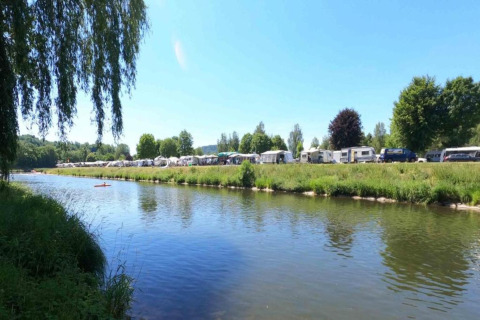 Vue sur la rivière au Resort Echternacherbrück 2 en Allemagne, avec caravanes, arbres et nature verdoyante