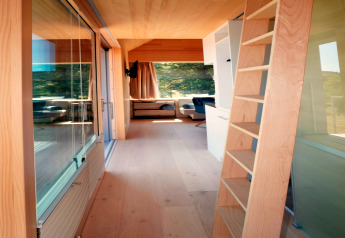 Interieur van de Haus Wasser-cabine in Duitsland met een houten ladder en grote ramen in modern ontwerp.