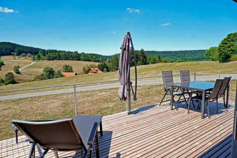 View from the terrace at Haus Wasser cabin in Germany with outdoor furniture and scenic hills.